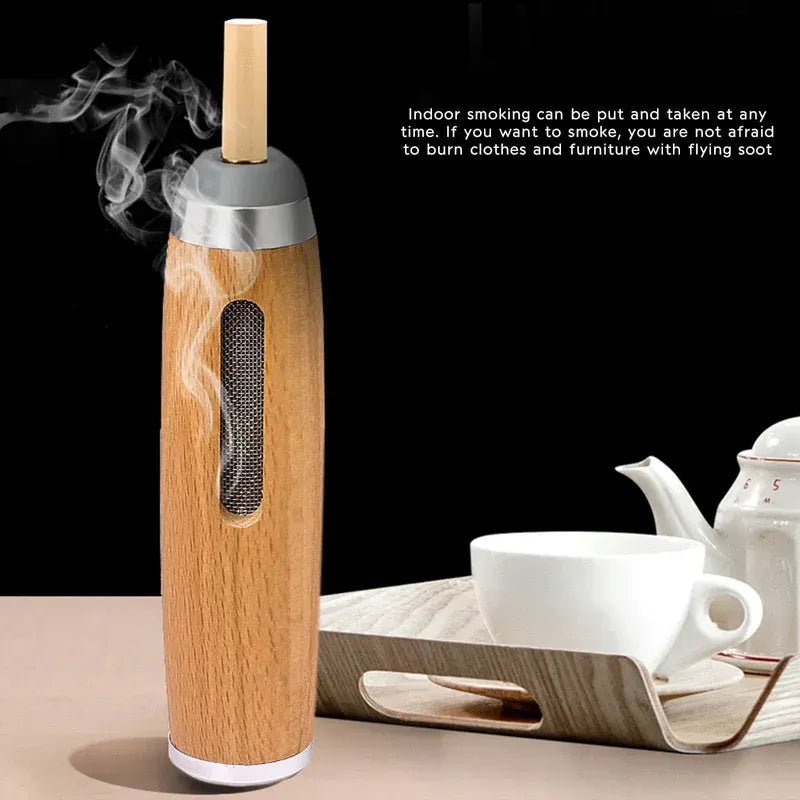 Wooden smoking device with smoke emerging, placed on a table with tea set in the background.
